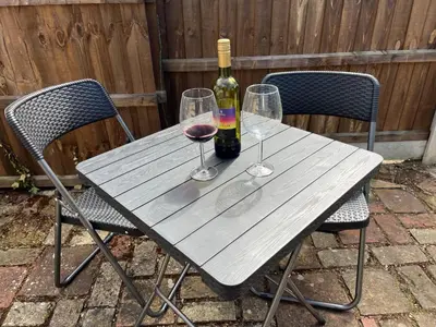 a table with two wine glasses and a bottle of wine at Harleston Norfolk Suffolk border Historic Cottage in Harleston