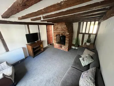 a living room with a couch and a fireplace at Harleston Norfolk Suffolk border Historic Cottage in Harleston