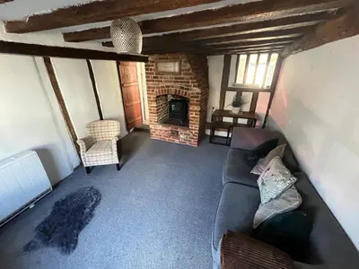 a living room with a couch and a fireplace at Harleston Norfolk Suffolk border Historic Cottage in Harleston