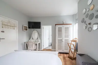 a white room with a toilet and a chair at Danes House 4 in Aldeburgh