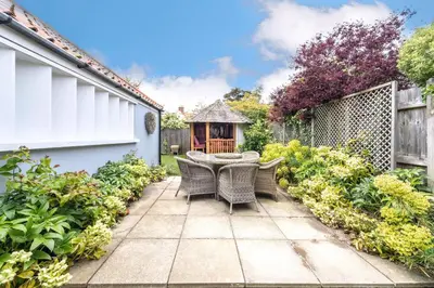a patio with a table and chairs in a garden at Danes House 4 in Aldeburgh