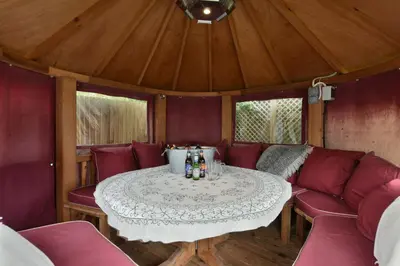a dining room with a table and red couch at Danes House 4 in Aldeburgh