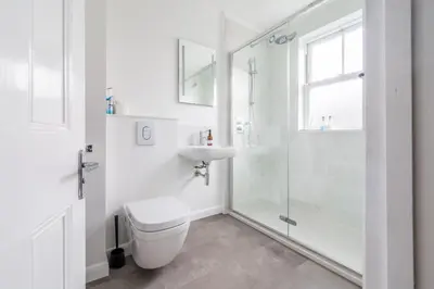 a white bathroom with a toilet and a sink at Danes House 4 in Aldeburgh