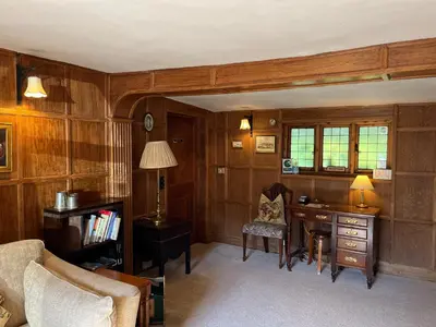 a living room with a desk and a chair at Little rooms at The Cottage in Bishops Stortford