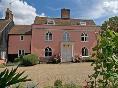 a large pink house with a large yard at Little rooms at The Cottage in Bishops Stortford