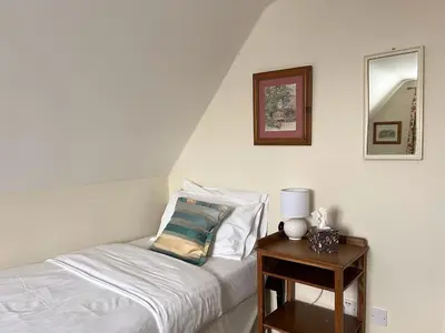 a bedroom with a bed and a table with a mirror at Little rooms at The Cottage in Bishops Stortford