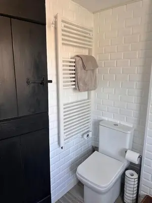 a white bathroom with a toilet and a towel at 2 Bedroom Cottage in Debenham - The Old Toll House in Debenham