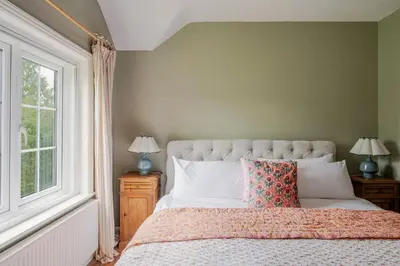 a bedroom with a bed with two lamps and a window at Boutique Suffolk Cottage Cosy Family Holiday Home with Garden Near Aldeburgh in Kettleburgh