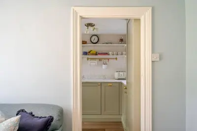 a door leading into a kitchen with a counter at Boutique Suffolk Cottage Cosy Family Holiday Home with Garden Near Aldeburgh in Kettleburgh