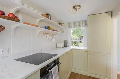 a kitchen with white cabinets and a counter top at Boutique Suffolk Cottage Cosy Family Holiday Home with Garden Near Aldeburgh in Kettleburgh