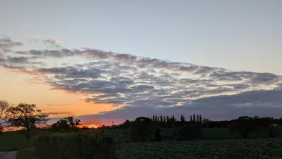 a cloudy sky at sunset with a field and trees at Boutique Suffolk Cottage Cosy Family Holiday Home with Garden Near Aldeburgh in Kettleburgh
