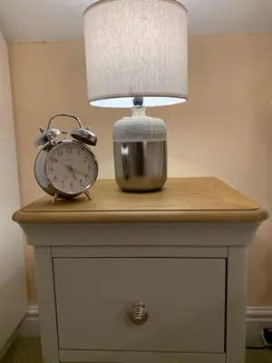 a table with a lamp and an alarm clock on it at The Pightle Annexe in Saffron Walden