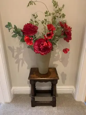 a vase filled with red flowers sitting on a table at The Pightle Annexe in Saffron Walden