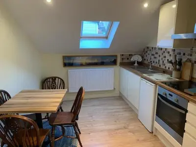 a kitchen with a table and chairs and a window at The Pightle Annexe in Saffron Walden