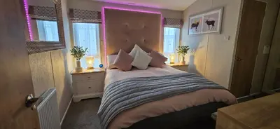 a bedroom with a large bed with pink lighting at The Pink Lady in Walton-on-the-Naze