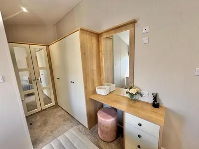 a bathroom with a wooden vanity and a mirror at The Pink Lady in Walton-on-the-Naze