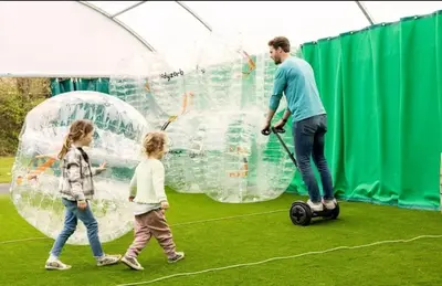 a man and two children playing with bubble balls at The Pink Lady in Walton-on-the-Naze