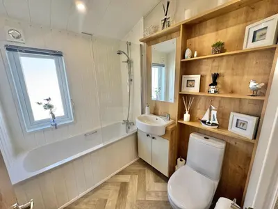 a bathroom with a toilet and a tub and a sink at The Pink Lady in Walton-on-the-Naze