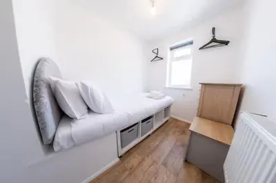 a living room with a white couch and a window at Stylish and comfortable 4-Bedroom Retreat in the Heart of Chelmsford in Chelmsford