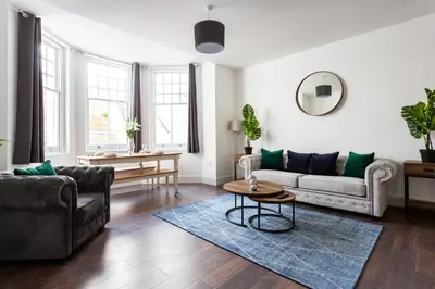 a living room with a couch and a table at Stylish & Modern Home by the Sea Near Three Shells in Southend-on-Sea