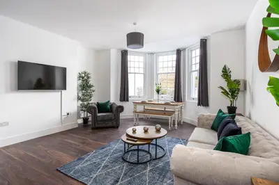 a living room with a couch and a table at Stylish & Modern Home by the Sea Near Three Shells in Southend-on-Sea