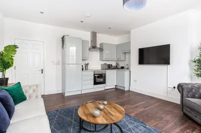 a living room with a couch and a table at Stylish & Modern Home by the Sea Near Three Shells in Southend-on-Sea