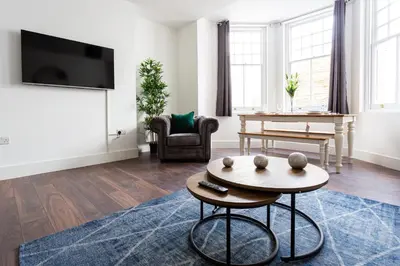 a living room with a tv and a table at Stylish & Modern Home by the Sea Near Three Shells in Southend-on-Sea