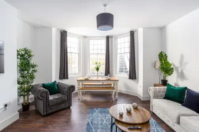 a living room with a couch and a table at Stylish & Modern Home by the Sea Near Three Shells in Southend-on-Sea