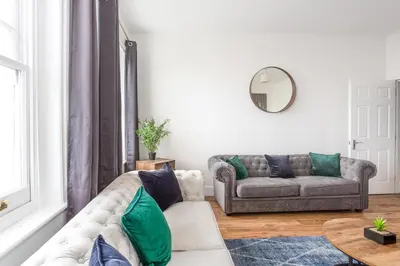 a living room with a couch and a table at 3 Bed Apartment with Balcony in Southend on Sea! in Southend-on-Sea