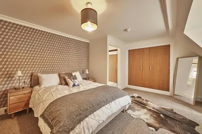 a bedroom with a large bed and a mirror at The Flat - Waresley Park Estate