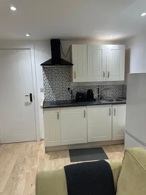 a kitchen with white cabinets and a counter top at A Lovely and Cosy Studio Apartment in Navestock