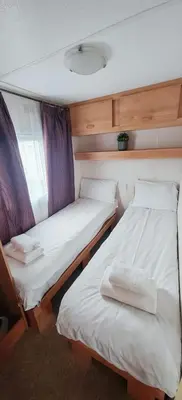 two beds in a small room in a boat at Dancing Seagulls Caravan in Clacton-on-Sea