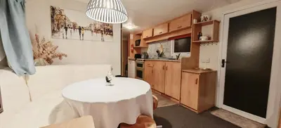 a living room with a table and a kitchen at Dancing Seagulls Caravan in Clacton-on-Sea