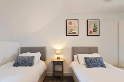 two beds sitting next to each other in a room at Modern town centre apartment in Bishops Stortford