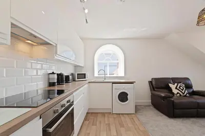 a kitchen with a sink and a washing machine at Modern town centre apartment in Bishops Stortford