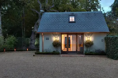a small white house with a black roof at Beech Cottage - one bedroom retreat with hot tub in Hatfield Broad Oak