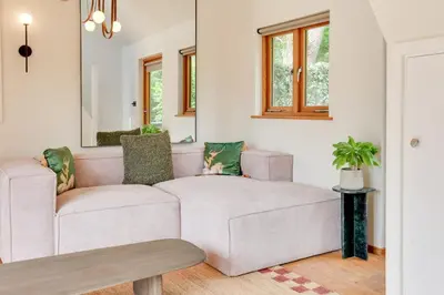 a living room with two white couches and a mirror at Beech Cottage - one bedroom retreat with hot tub in Hatfield Broad Oak