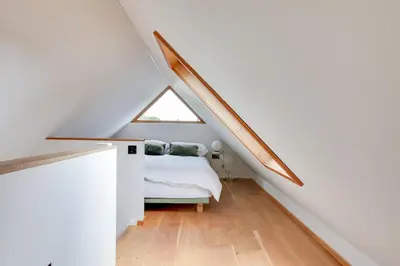 a room with a bed in a attic with a window at Beech Cottage - one bedroom retreat with hot tub in Hatfield Broad Oak