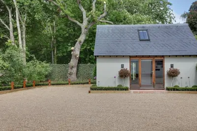 a small white house with a black roof at Beech Cottage - one bedroom retreat with hot tub in Hatfield Broad Oak
