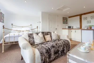 a living room with a couch and a bed at Stansted airport - studio annexe with parking in Hatfield Broad Oak