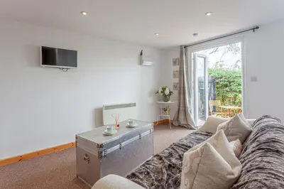 a living room with a couch and a table at Stansted airport - studio annexe with parking in Hatfield Broad Oak