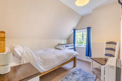 a bedroom with a bed and a chair and a window at 3 Bed in Stowupland oc-p32216 in Stowmarket