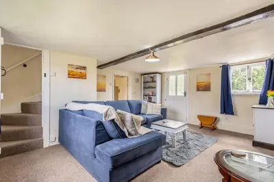 a living room with a blue couch and stairs at 3 Bed in Stowupland oc-p32216 in Stowmarket