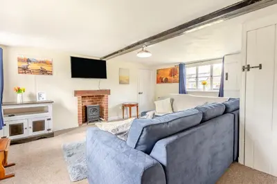 a living room with a blue couch and a fireplace at 3 Bed in Stowupland oc-p32216 in Stowmarket