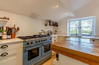 a kitchen with a stove and a wooden counter top at 4 Bed in Sudbourne oc-w32267 in Sudbourne