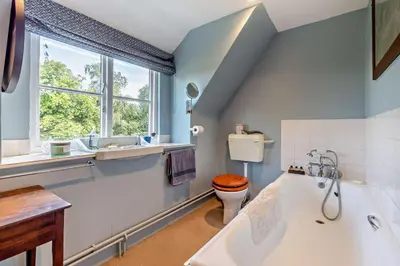 a bathroom with a tub and a toilet and a window at 4 Bed in Sudbourne oc-w32267 in Sudbourne