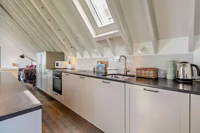 a kitchen with white cabinets and a black counter top at 2 Bed in Sudbourne oc-w32264 in Sudbourne