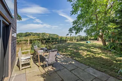 a patio with a table and chairs and a tree at 2 Bed in Sudbourne oc-w32264 in Sudbourne