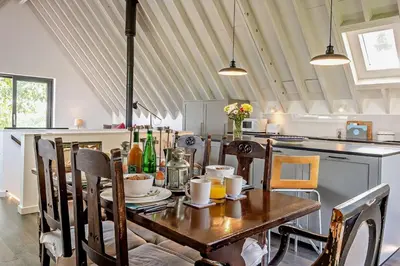 a dining room with a table and a kitchen at 2 Bed in Sudbourne oc-w32264 in Sudbourne