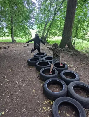 two children playing on tires in a park at Stables 2bed farm stay private firepit bbq in Bramfield